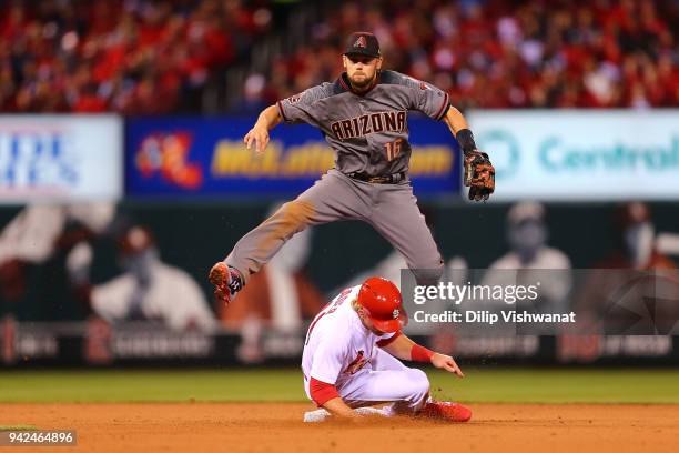 Chris Owings of the Arizona Diamondbacks turns a double play over Harrison Bader of the St. Louis Cardinals in the fifth inning at Busch Stadium on...