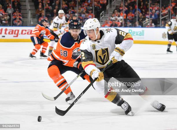Zach Whitecloud of the Vegas Golden Knights skates skates with the puck while being pursued by Anton Slepyshev of the Edmonton Oilers on April 5,...