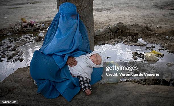 Afghan widowed women have little option but to beg for money and food in order to survive, such as this women with her small child in Kabul.