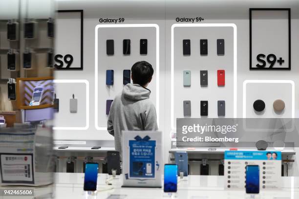 Customer looks at accessories for Samsung Electronics Co. Galaxy S9 smartphone at the company's D'light flagship store in Seoul, South Korea, on...