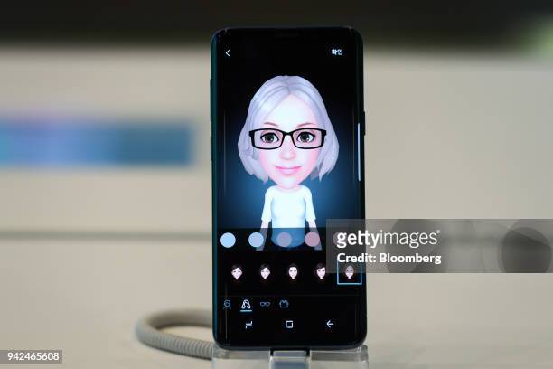 An animated emoji is displayed on-screen on a Samsung Electronics Co. Galaxy S9 smartphone at the company's D'light flagship store in Seoul, South...