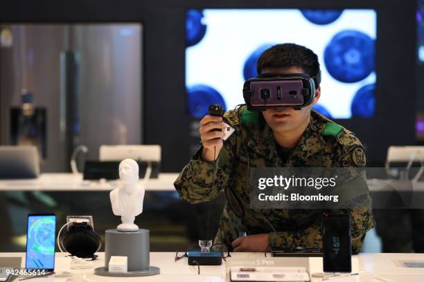 South Korean army soldier tries out a Samsung Electronics Co. Galaxy Gear virtual reality headset at the company's D'light flagship store in Seoul,...