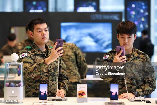 South Korean army soldiers try out Samsung Electronics Co. Galaxy S9+ smartphones at the company's D'light flagship store in Seoul, South Korea, on...