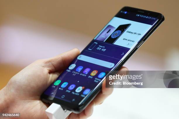 Customer holds a Samsung Electronics Co. Galaxy S9+ smartphone at the company's D'light flagship store in Seoul, South Korea, on Thursday, April 5,...