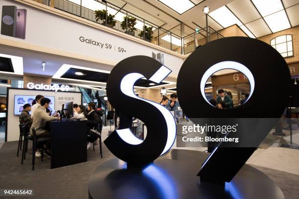 Customers try out Samsung Electronics Co. Galaxy S9 smartphones at one of the company's promotional booths in Seoul, South Korea, on Thursday, April...
