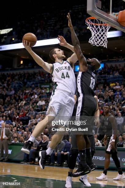 Tyler Zeller of the Milwaukee Bucks attempts a shot while being guarded by Quincy Acy of the Brooklyn Nets in the third quarter at the Bradley Center...