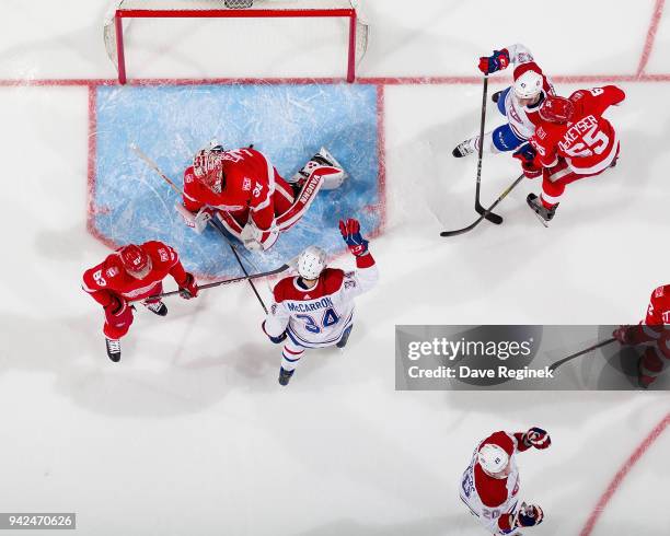 Nicolas Deslauriers of the Montreal Canadiens scores a first period goal past Jared Coreau of the Detroit Red Wings as Michael McCarron and Daniel...