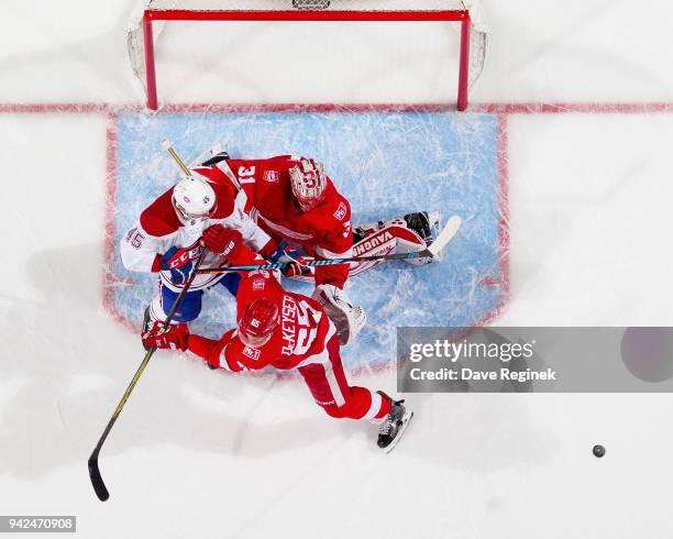 Kerby Rychel of the Montreal Canadiens battles for position with Danny DeKeyser and goaltender Jared Coreau of the Detroit Red Wings during an NHL...