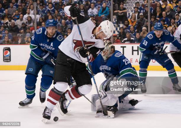 Richard Panik of the Arizona Coyotes looks for the loose puck after goalie Jacob Markstrom of the Vancouver Canucks made a save in NHL action on...