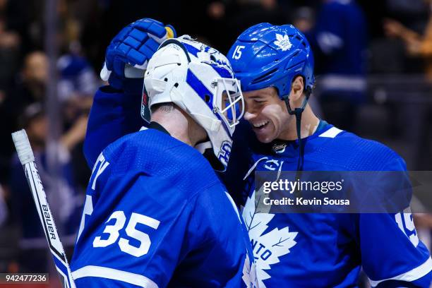 Matt Martin of the Toronto Maple Leafs celebrates with teammate Curtis McElhinney after defeating the Buffalo Sabres at the Air Canada Centre on...