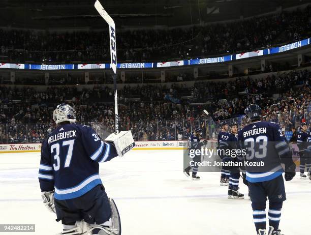 Goaltender Connor Hellebuyck of the Winnipeg Jets salutes the fans as he and teammates leave the ice following a 2-1 victory over the Calgary Flames...