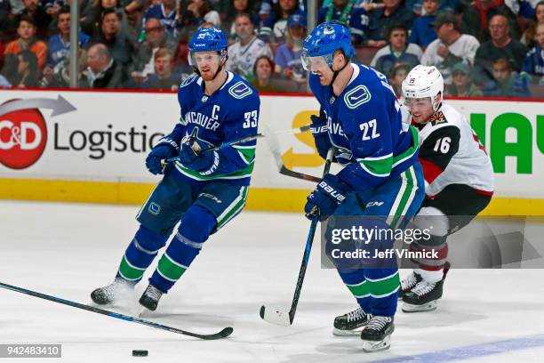 Max Domi of the Arizona Coyotes checks Daniel Sedin of the Vancouver Canucks during their NHL game at Rogers Arena April 5, 2018 in Vancouver,...