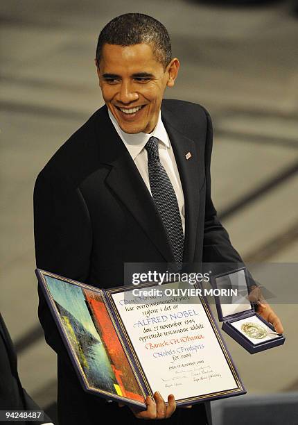 Nobel Peace Prize laureate, US President Barack Obama poses on the podium with his diploma and gold medal during the Nobel ceremony at the City Hall...