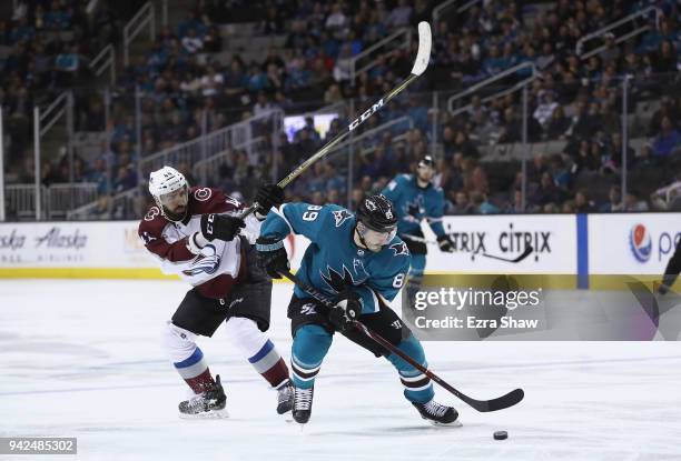 Mark Barberio of the Colorado Avalanche tries to get the puck from Mikkel Boedker of the San Jose Sharks at SAP Center on April 5, 2018 in San Jose,...