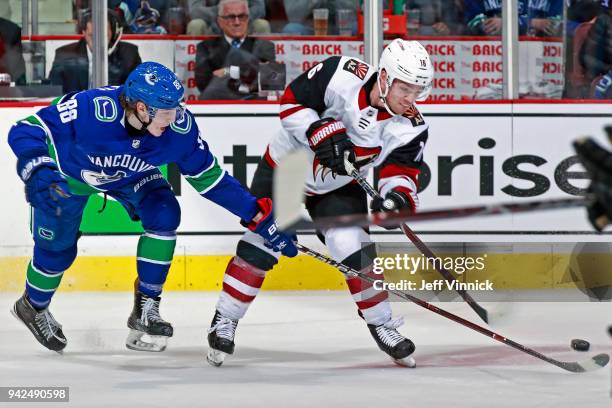 Adam Gaudette of the Vancouver Canucks checks Max Domi of the Arizona Coyotes during their NHL game at Rogers Arena April 5, 2018 in Vancouver,...