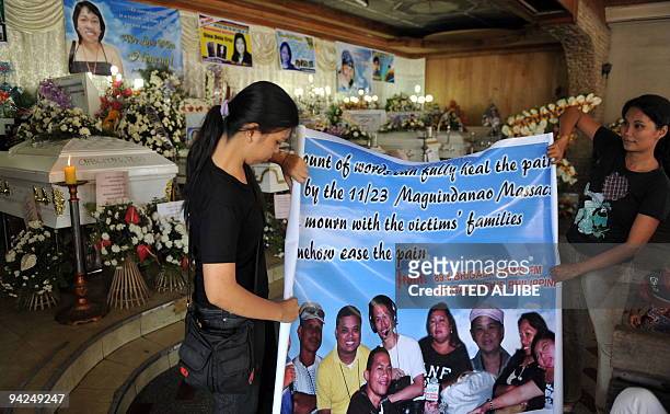 Relatives fold a collage of slain journalists during the wake at a funeral home in General Santos City, South Cotabato on November 30, 2009. A...