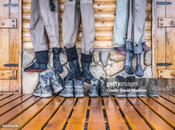 fishing boots and waders in lodge - wading boots stock pictures, royalty-free photos & images