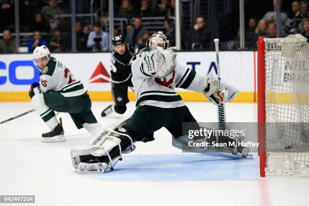 Dustin Brown of the Los Angeles Kings shoots the winning overtime goal as Jonas Brodin and Alex Stalock of the Minnesota Wild defend during a game at...