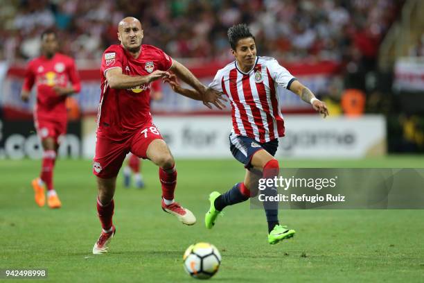 Carlos Cisneros of Chivas fights for the ball with Aurelien Collin of New York RB during the semifinal match between Chivas and New York RB as part...