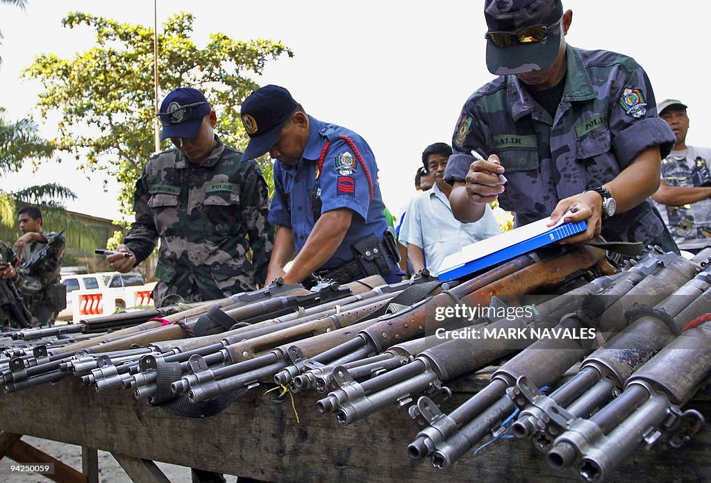 Policemen check firearms surrenderd by c