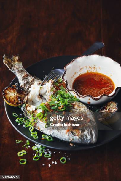 barbecued whole snapper with sauce - snapper fish stock pictures, royalty-free photos & images