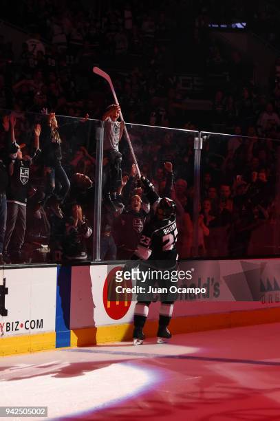 Dustin Brown of the Los Angeles Kings hands his hockey stick to a young fan after being recognized as a player of the game against the Minnesota Wild...