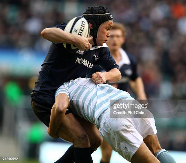 Allfrey of Oxford University gets tackled by J.R.Richards of Cambridge University during the Nomura Varsity Rugby match between Oxford University and...