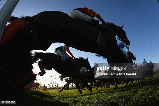 Horses and riders jump a fence during the Totesuper7 Handicap Hurdle race at Huntingdon Racecourse on December 10, 2009 in Huntingdon, England.