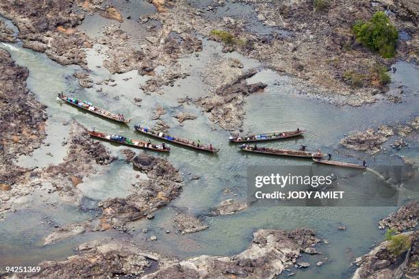 Aerial view taken on November 14, 2009 shows dugout canoes transporting fuel supplies go up the Maroni river in the French oversea department of...