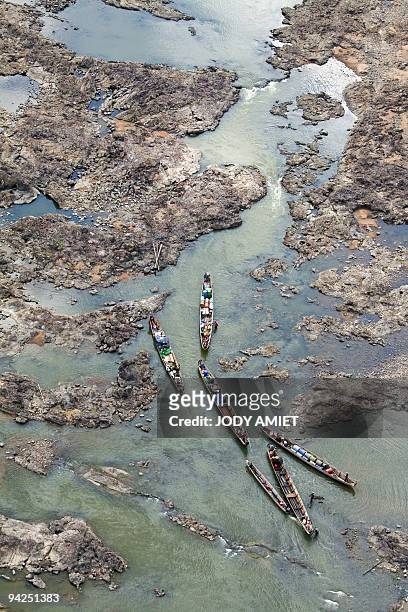 Aerial view taken on November 14, 2009 shows dugout canoes transporting fuel supplies go up the Maroni river in the French oversea department of...