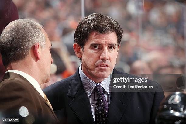 Head Coach Peter Laviolette of the Philadelphia Flyers watches the play develop from behind the bench against the New York Islanders on December 8,...