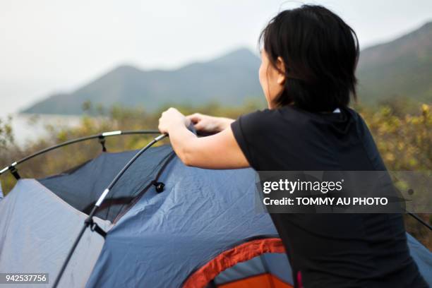 asian woman pitching tent - picchetto da tenda foto e immagini stock