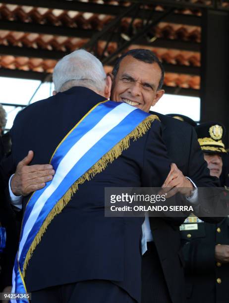 Honduran de facto President Roberto Micheletti embraces Honduran elected President Porfirio Lobo, during an army ceremony in Tegucigalpa on December...
