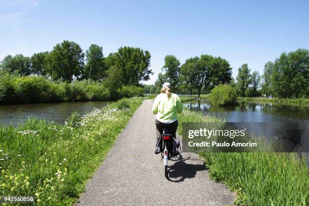 a woman enoying at bosbaan park in amsterdam - bosbaan photos et images de collection