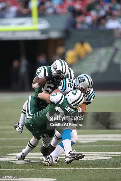 Safety Eric Smith and Linebacker David Harris of the New York Jets stop Tight End Gary Barnidge of the Carolina Panthers at Giants Stadium on...