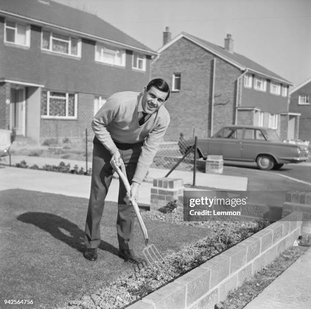 British soccer player John Milkins of Portsmouth FC doing some gardening in his house's front yard, UK, 10th March 1968.