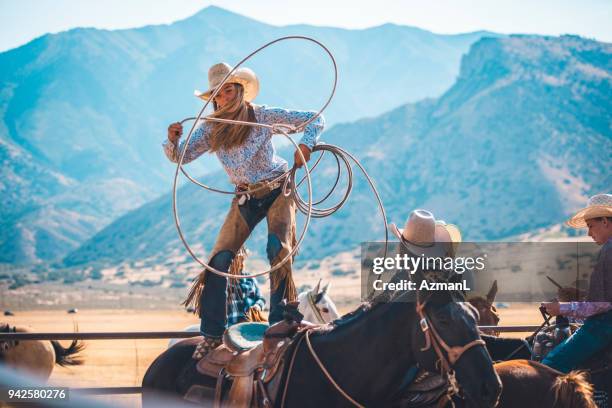 cowgirl mit dem lasso in rodeo arena - sattel und zaumzeug stock-fotos und bilder