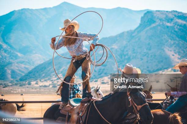 cowgirl lassoing in rodeo arena - cowgirl stock pictures, royalty-free photos & images