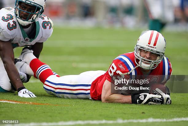 Wide receiver Wes Welker of the New England Patriots and Nathan Jones of the Miami Dolphins look toward the line judge after Welker was brought down...