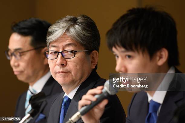 Oki Matsumoto, president and chief executive officer of Monex Group Inc., center, looks towards Koichiro Wada, president of Coincheck Inc., right, as...