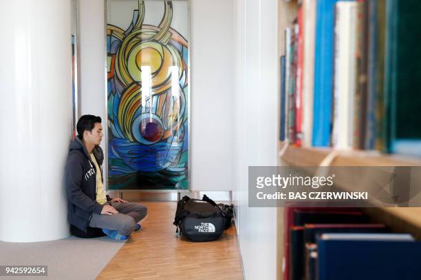 Man sits crossed legged in the Meditation Centre, where passengers can pray and mediate, at Schiphol Airport, Schiphol on April 6, 2018. / AFP PHOTO...