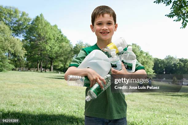 little boy with handful of recycling - environmental conservation fotografías e imágenes de stock