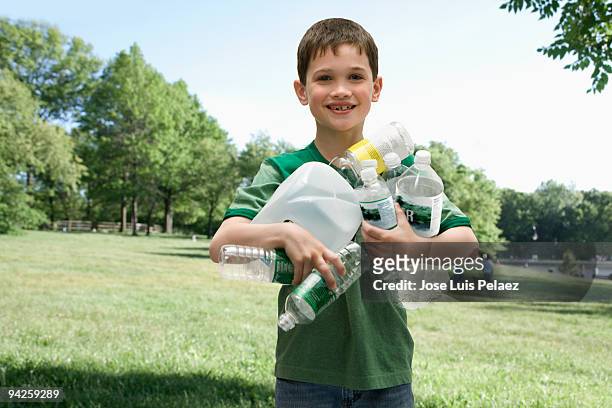 little boy with handful of recycling - environmental conservation plastics stock pictures, royalty-free photos & images