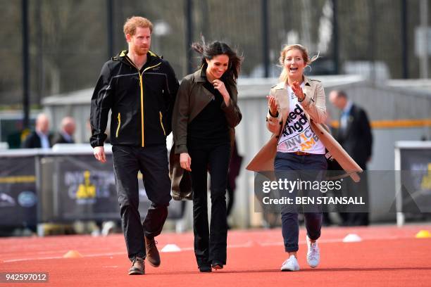 Britain's Prince Harry and his fiancee US actress Meghan Markle walk with Invictus Games UK Team Chef de Mission Jayne Kavanagh as they arrive and to...