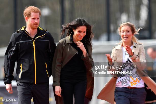 Britain's Prince Harry and his fiancee US actress Meghan Markle walk with Invictus Games UK Team Chef de Mission Jayne Kavanagh as they arrive and to...