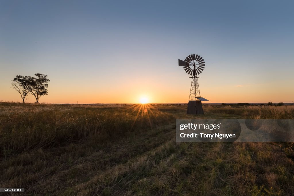 Sunset falling behind a windmill.