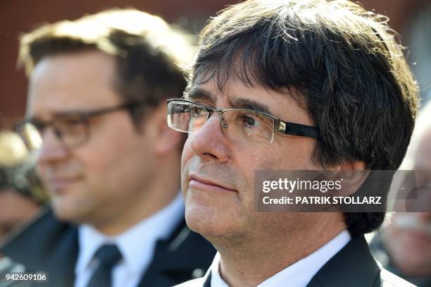 Catalonia's ousted leader Carles Puigdemont listens to his German lawyer talking to journalists, as he leaves the detention centre of Neumuenster,...