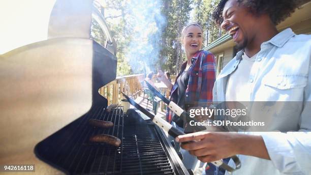 young man grill bratwurst while on vacation with friends - couple grilling stock pictures, royalty-free photos & images