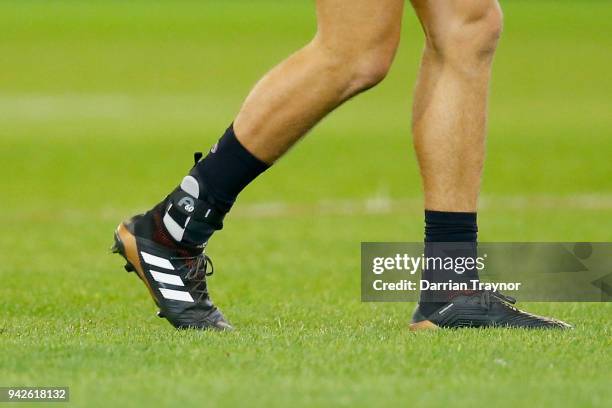 Caleb Marchbank of the Blues comes back onto the ground with an ankle brace on his injured root foot during the round three AFL match between the...