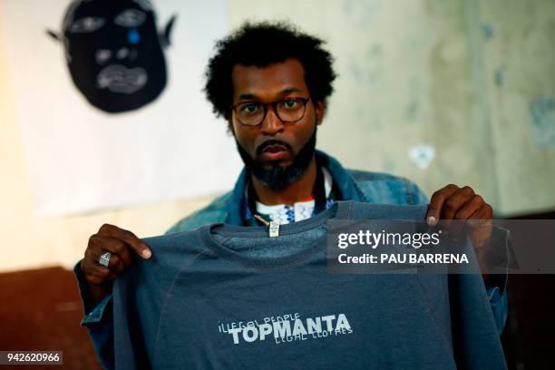 Member of 'Sindicato Popular de Vendedores Ambulantes' Senegalese vendor Mouhamed, shows a t-shirt of their new crowdfunded trademark project 'Top...